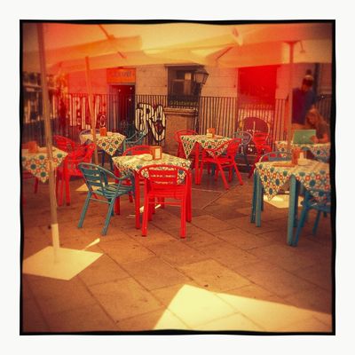 Plastique 120: an empty café terrace, glowing orange with dark corners
