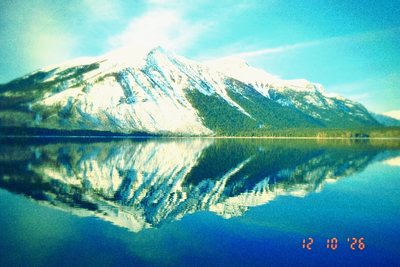 Kompakt LC: snowy mountains in a still lake, cross-processed teal with a red date