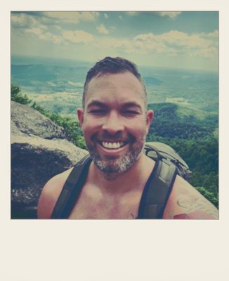 Phold-75: a smiling hiker on a summit, instant print with a deep white chin