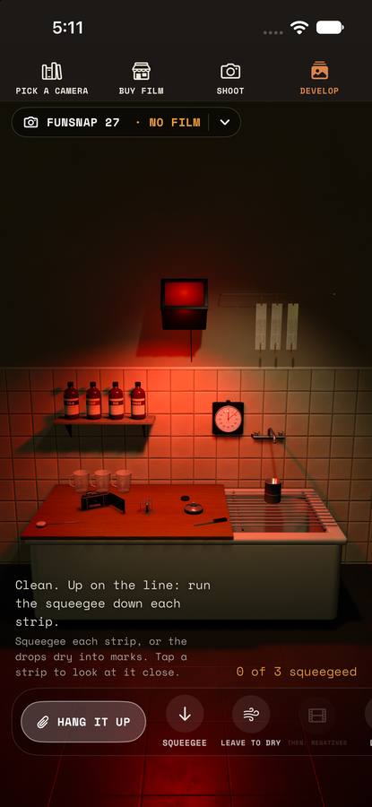 The darkroom under a red safelight: a sink, trays and negatives hanging up to dry